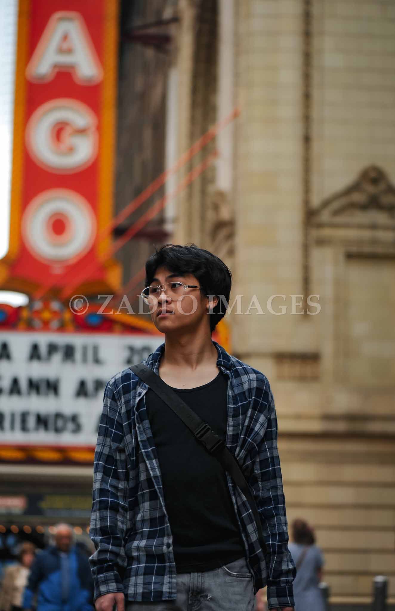 Teen boy in front of Chicago Theater sign.