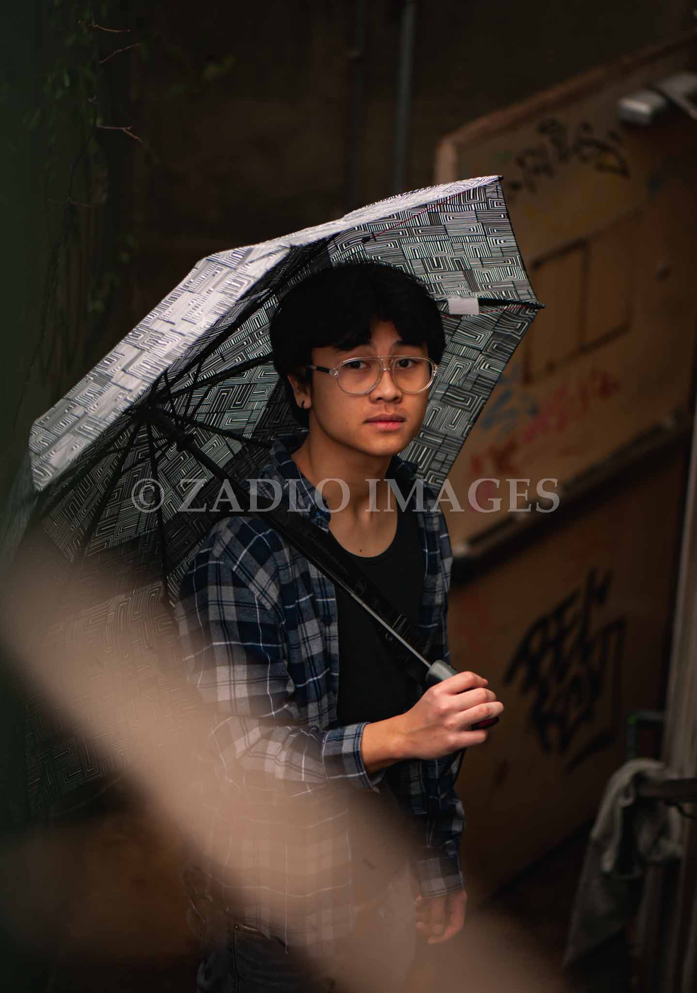 Teen boy holding umbrella.