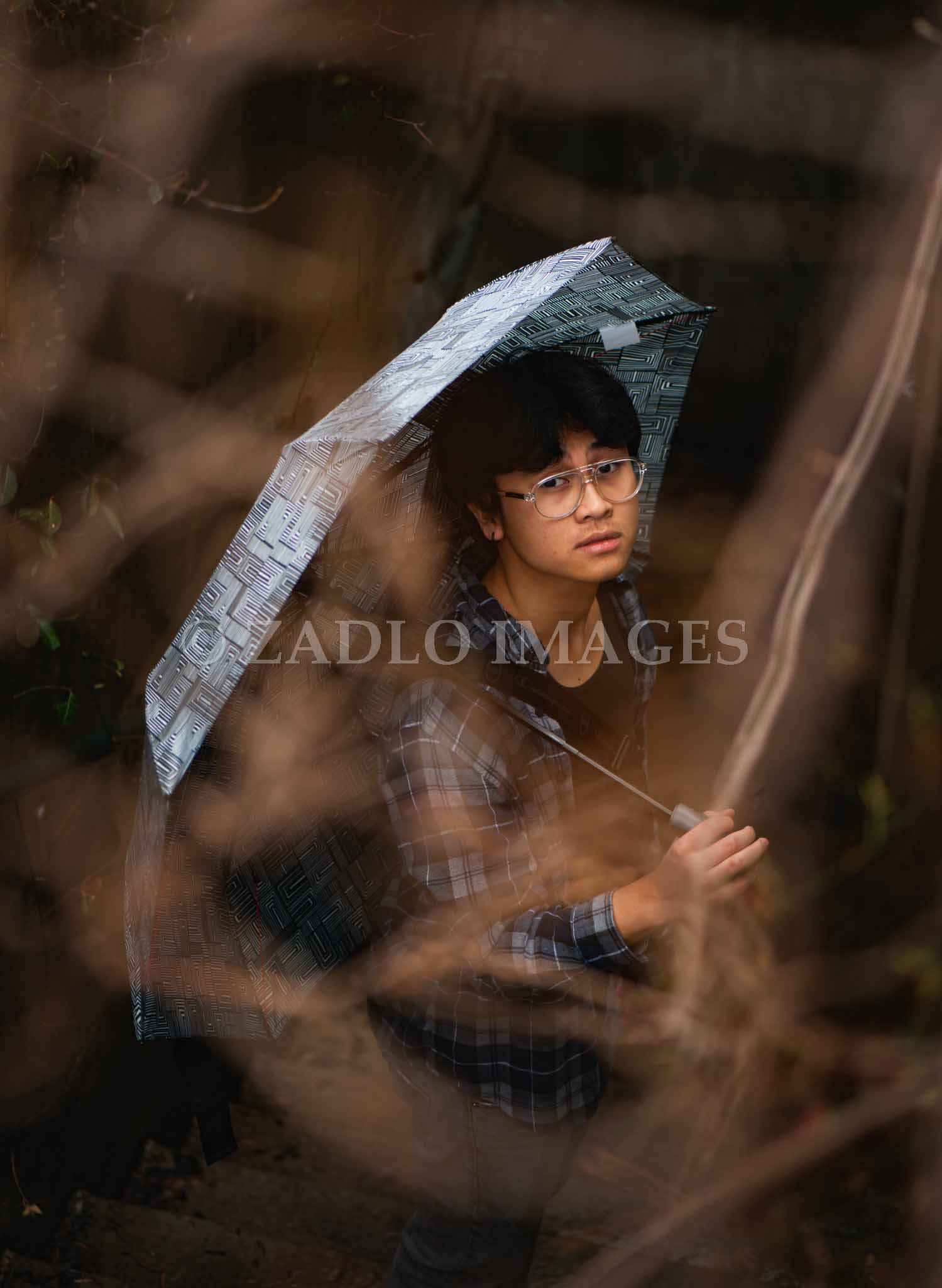 Teen boy holding umbrella.